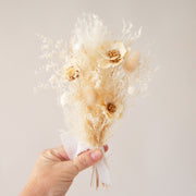 A bouquet of neutral white and tan dried and preserved florals.