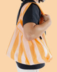 A nylon reusable bag with tangerine wide stripes.