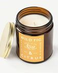 On a white background is an amber colored jar candle with a yellow label and white text that reads, "Wild Fig & Citrus".