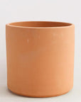 On a white background is a terracotta cylinder planter with a raw terracotta finish.