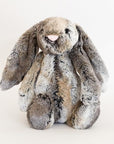 Soft stuffed animal mottled grey and gold rabbit with long floppy ears, legs and feet.