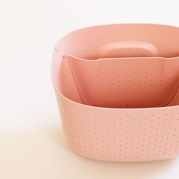 This photograph shows an arial view of the pink planter when its empty showing there are two separate compartments in the planter, a thinner opening on the back that holds the water along with small circle holes to water the plant and then a larger opening in front to place a plant also with small holes in the front for ventilation and drainage if necessary.