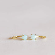 Gold huggie style earrings with set aqua colored amazonite gem.