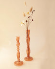 A thin glass bud vase with intricate details in an amber shade.