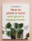 A white book with a green leafy plant and a title that reads, "How to plant a room and grow a happy home."