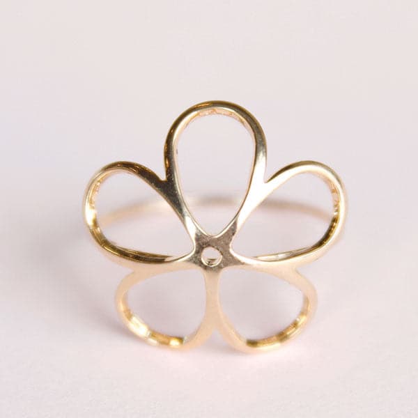 Gold ring in the shape of a flower with large open petals.