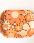 A metal tray perfect for rolling or all your favorite trinkets. It features a 70's inspired floral design with a variation of daisies in different shapes, sizes and colors.