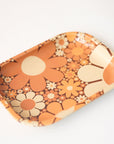 A metal tray perfect for rolling or all your favorite trinkets. It features a 70's inspired floral design with a variation of daisies in different shapes, sizes and colors.