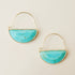 In front of a cream background is a pair of gold earrings. The top is a thin gold hoop. The bottom is a turquoise half circle with a gold border. 