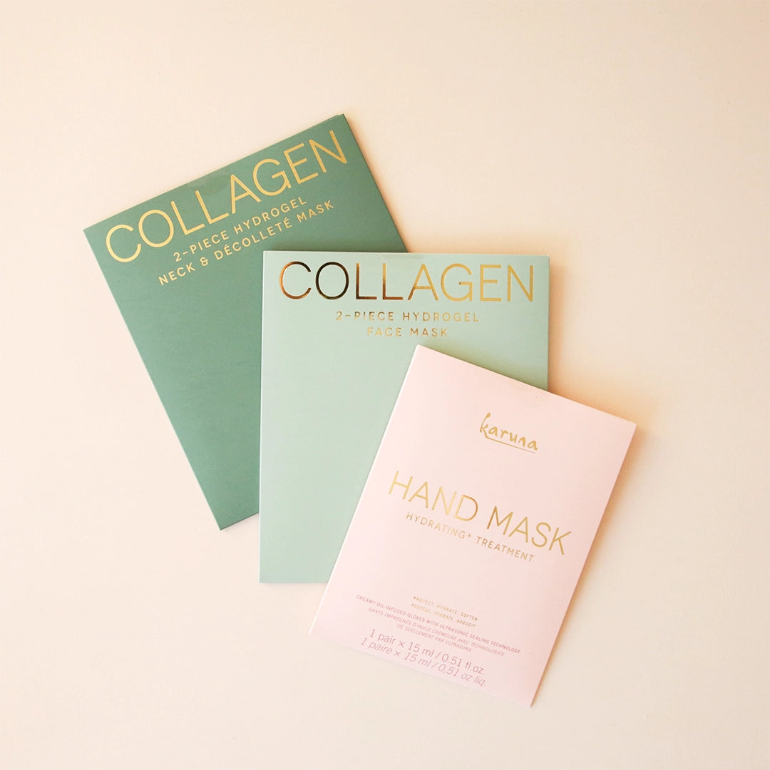 On a cream background is a pink packet with a hand mask inside that reads, &quot;Karuna Hand Mask Hydrating + Treatment&quot; and photographed here with two other green packets of collagen masks sold separately. 
