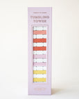 Against a white background is a light purple box with a set of wood blocks stacked upon one another ranging from white to shades of pink, red, and yellow along with letters at the top of the box that read, "Tumbling Tower".