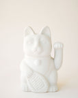 A ceramic lucky cat vase in white with its paw up in the waving position.