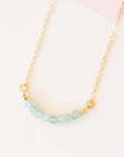 Eight amazonite beads lined up on a gold chain.
