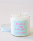 Clear, glass jar candle with white metal lid. Label says "Exhale the bullshit" in pink with a aqua colored background.