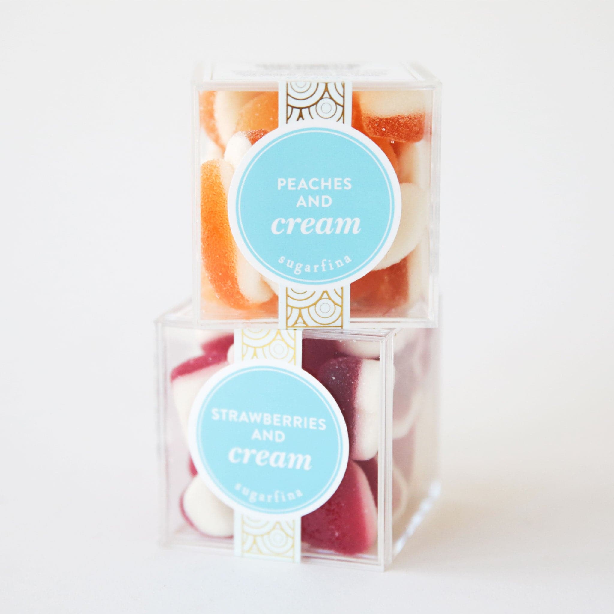 Two clear acrylic boxes with peaches and cream and strawberries and cream candies inside. 