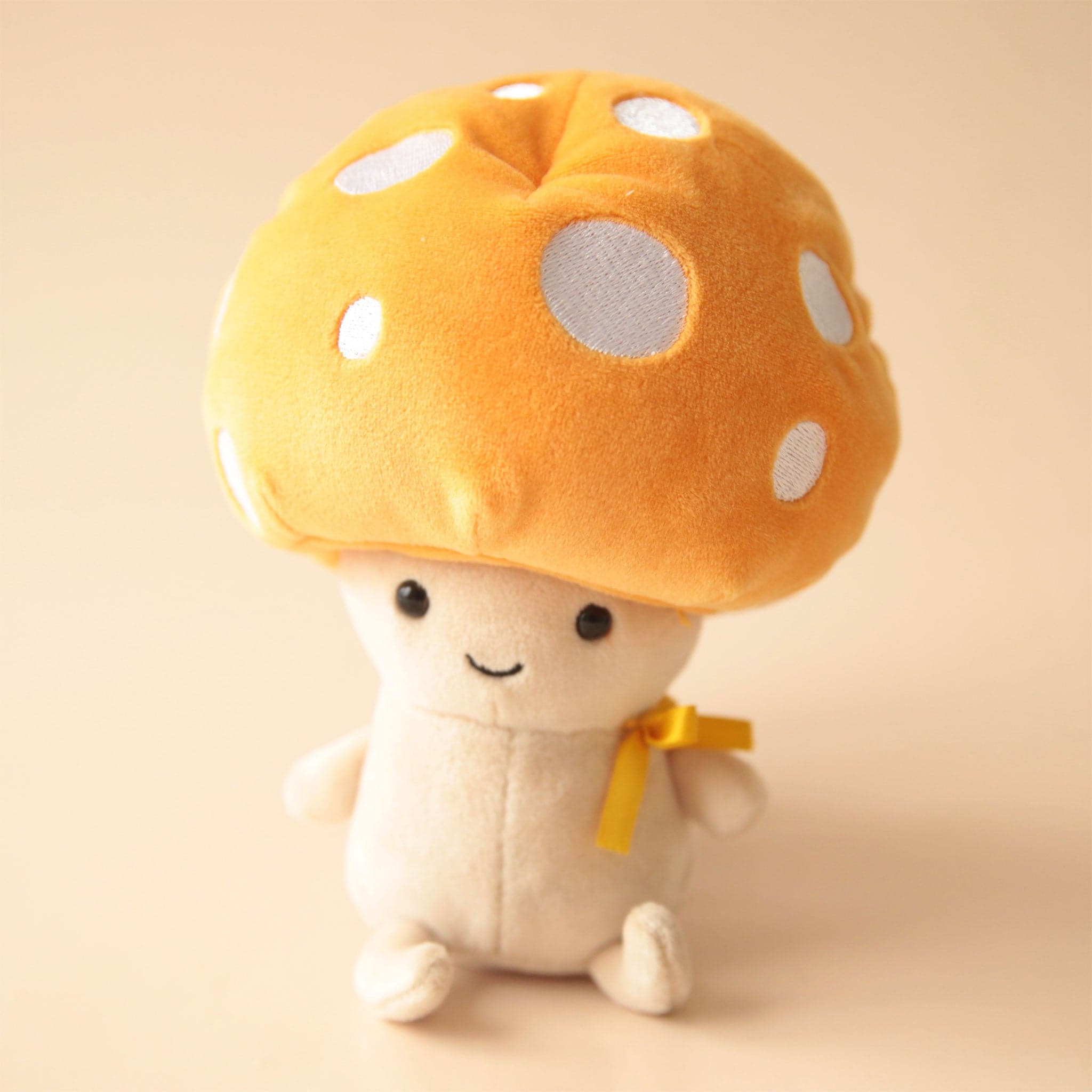 A sweet cuddling mushroom guy with a yellow and white spotted top and cream body.