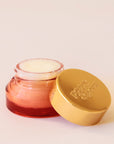 Lip scrub in an orange red container with a gold lid. This lip scrub is grainy, hydrating and perfect for your lips.