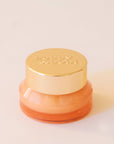 Lip scrub in an honeydew colored container with a gold lid. This lip scrub is grainy, hydrating and perfect for your lips.