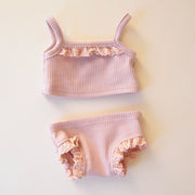 A rib knit tank top and shorts set in light pink color with lace detailing on the top and the sides of the shorts. 