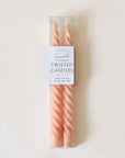 Pair of two pastel pink, twisted taper candles with white wicks are positioned beside each other in clear plastic packaging. The packaging is taped 'Terracotta Tapered Twisted Candles'.