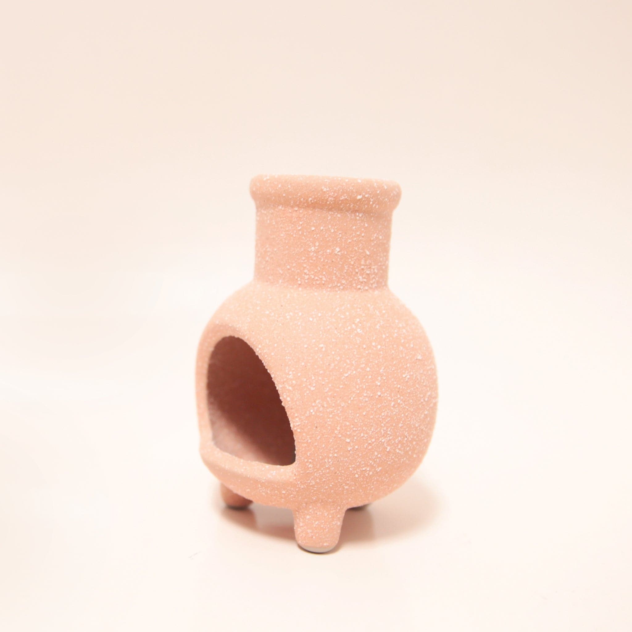 A tiny terracotta chiminea with legs and an opening for the incense cones to sit inside.