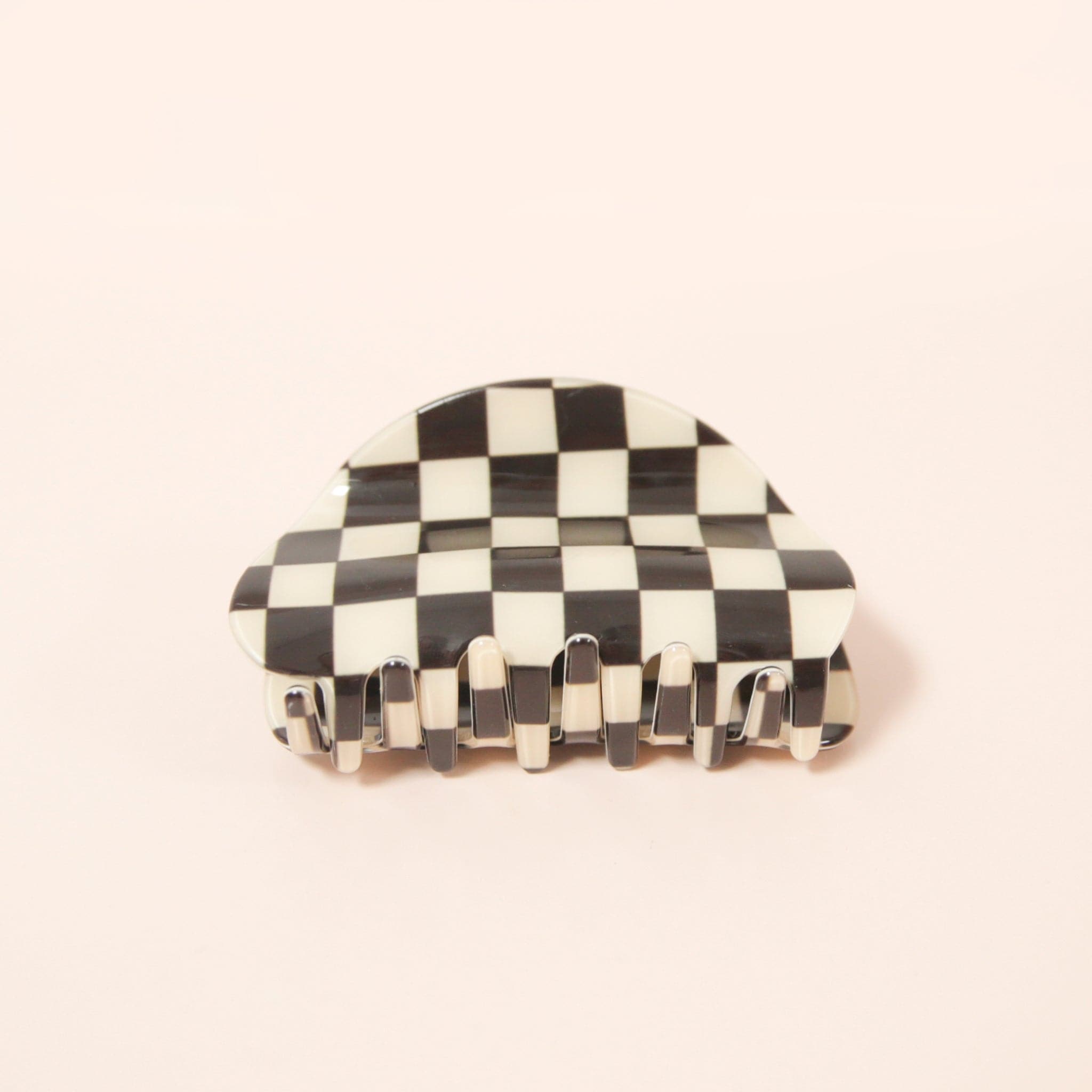 A black and white checkered claw clip with a rounded edge detail.