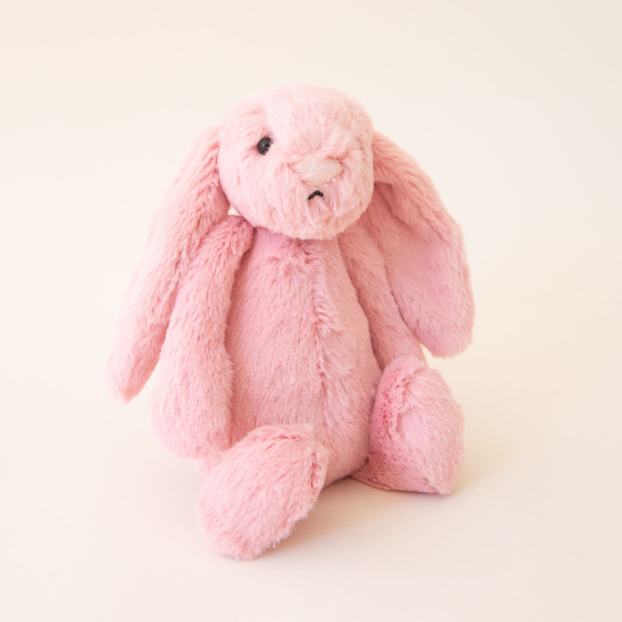 The smaller version of the fuzzy pink bunny with the same exact look, with long floppy ears but in a smaller size.