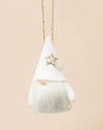 A plush white gnome ornament with a gold star and beard on a neutral ground.