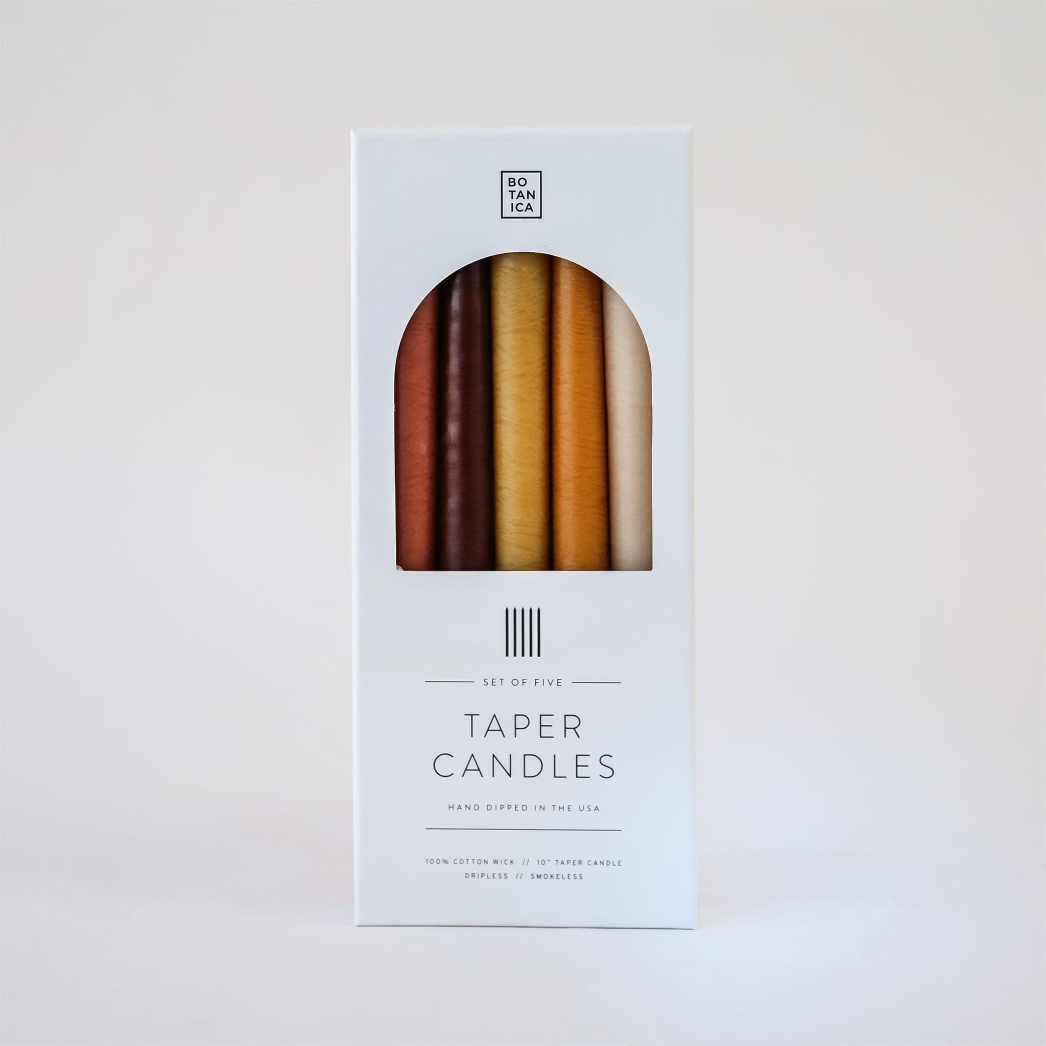 Set of five, 10 inch taper candles that come in deep warm toned natural colors packaged in white Botanica branded box.