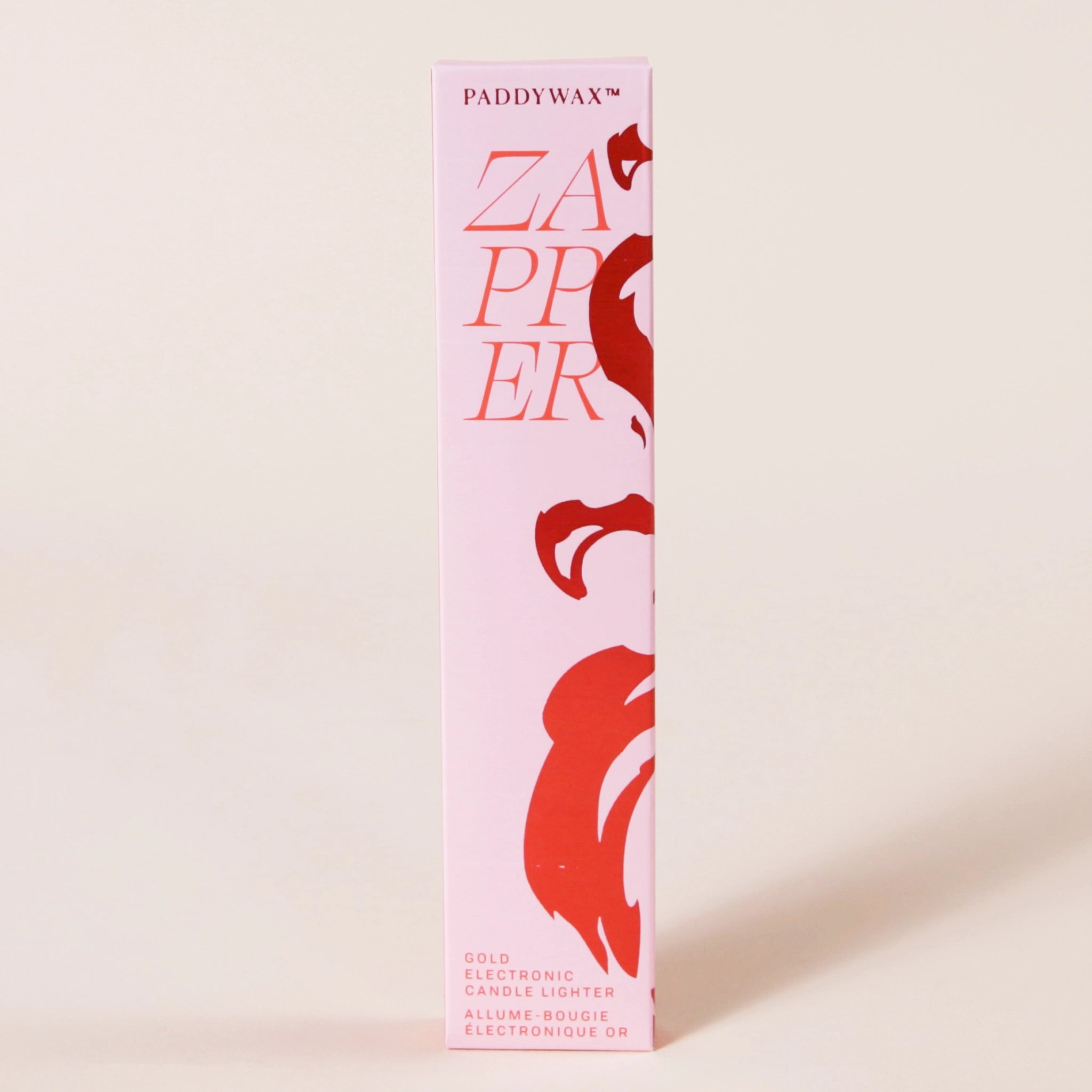 A pink box with a red wavy design and text that reads, "Paddywax Zapper Gold Electric Candle Lighter".