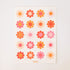 White sticker sheet containing 20 70's style flowers in various colors of orange, red, pink.
