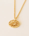 Gold chain necklace complete with circle pendant. The outline of a pleasant daisy is carved out of the pendent.