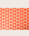 Sheet of wrapping paper filled with vertical stripes of bright and pastel orange flowers.