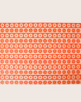 Sheet of wrapping paper filled with horizontal stripes of bright and pastel orange flowers.
