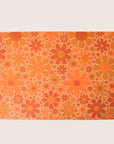 Sheet of wrapping paper filled with orange and yellow flowers of various shapes and sizes.