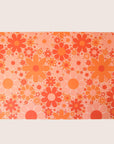 Sheet of wrapping paper filled with orange and pink flowers of various shapes and sizes.