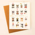 On a cream background is a photograph of a white card and a gold envelope. On the card is 16 various breeds of cats in all different colors wearing party hats, sunglasses and bowties along with gold text in the center that reads, "Happy Birthday".