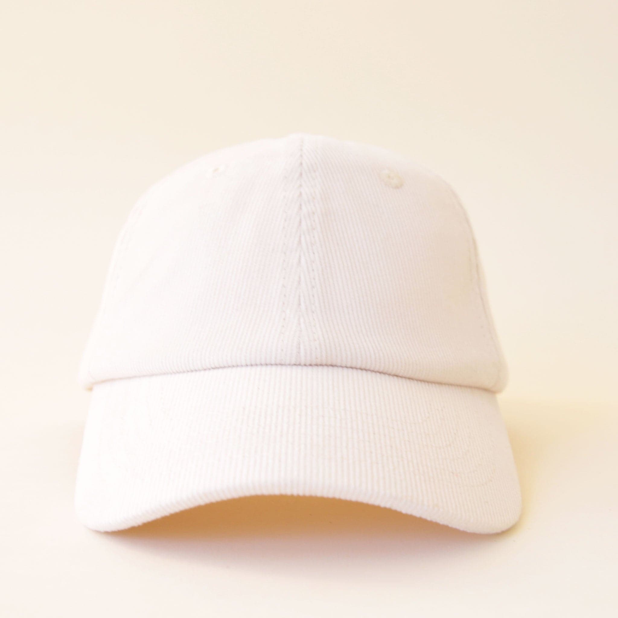 An ivory corduroy baseball hat with a curved bill.