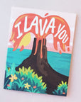 A card featuring an illustration of a tropical scene with the ocean in the background and a volcano erupting with red lava and white letters that read, " I Lava You".