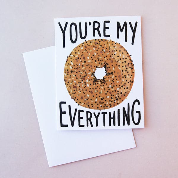 Idlewild Everything Bagel Folded Card - featuring a photograph of a white folded card with a graphic of an everything bagel along with &quot;You&#39;re My Everything&quot; in black text.