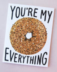 Idlewild Everything Bagel Folded Card - featuring a photograph of a white folded card with a graphic of an everything bagel along with "You're My Everything" in black text.