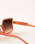 70's inspired square sunglasses with an oversized cognac colored frame and a brown lens.