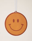 A yellow smiley face car air freshener.
