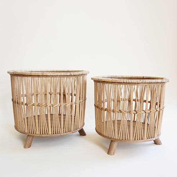 Two bamboo woven baskets with three feet. One is slightly larger than the other.
