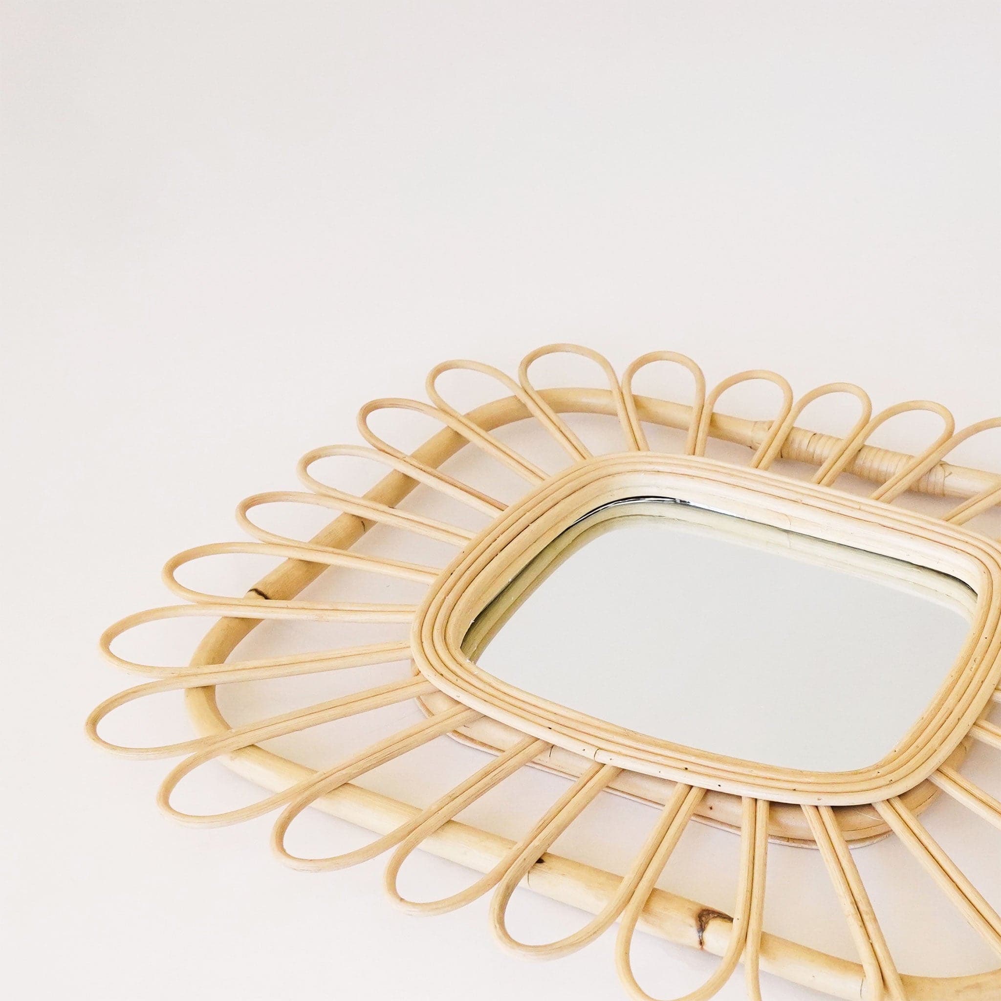 Rectangle shaped mirror with a piped rattan design.