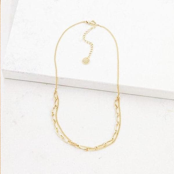 A gold two chain necklace, one is a thin chain the other a large chain.