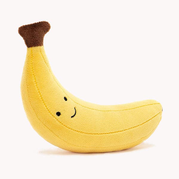On a white background is a yellow banana kids stuffed animal with a smiling face. 