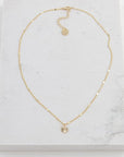A dainty gold chain with a small circle pendant.