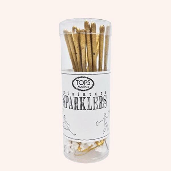 A clear container of miniature gold sparklers with a white label around the center of the container that reads, &quot;Tops Malibu Miniature Sparklers&quot; in black letters. 
