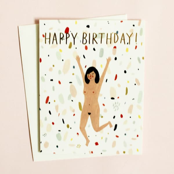 White and terrazzo patterned greeting card with illustrated women running naked, "happy birthday!" in gold foil, and white envelope.